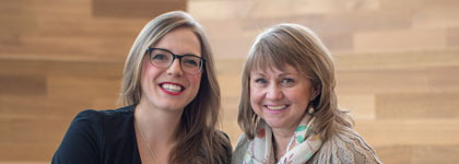 Photo of two people smiling at the camera. 