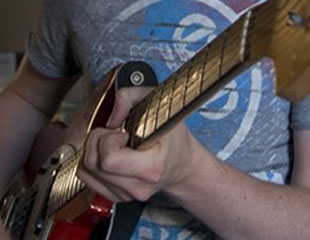 A photograph of a person playing the electric guitar. 