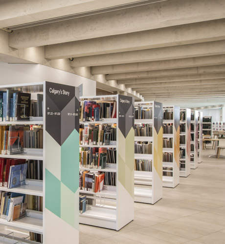 A row of Library bookshelves with colorful geometric patterns and a sign indicating a section dedicated to Calgary's history.