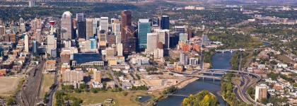 A aeriel view of Calgary's downtown core, showcasing the city's skyline with mordern skyscrapers.