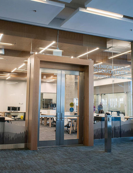 Glass doors with a wooden frame leading into the Glenbow Western Research Centre.