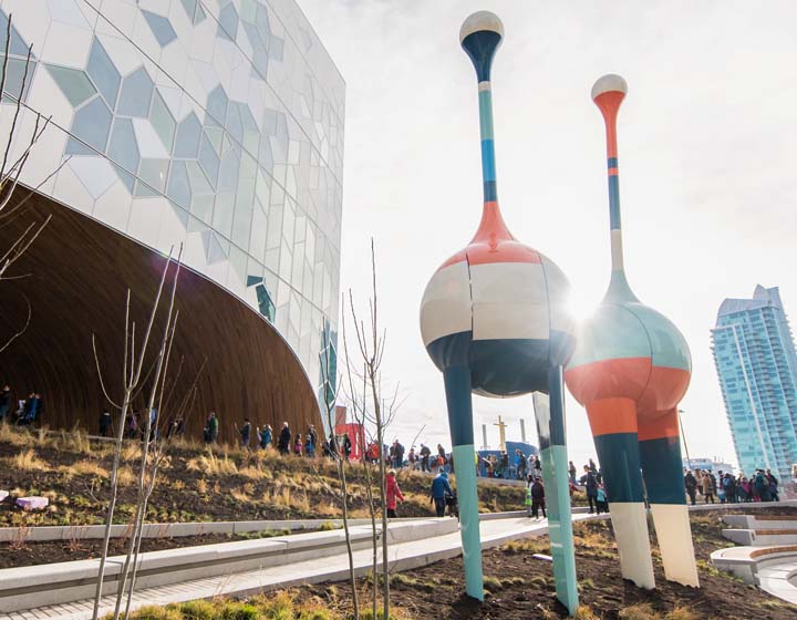 background image: Three colourful structures that move like a pendulum outside of Central Library.