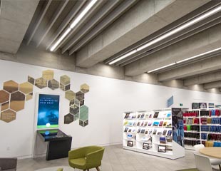 A photography of Calgary's Story. On the left hand side there is a display that says "Glimpses of Our Past" with different images in a hexagon format above it. On the right side is a row of bookshelves with Calgary's  Story written on the side of them.