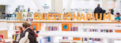 This is a visual of bookshelves with the word "Questionarium" in orange letters on top. Sitting below, a family is playing a game at the table.