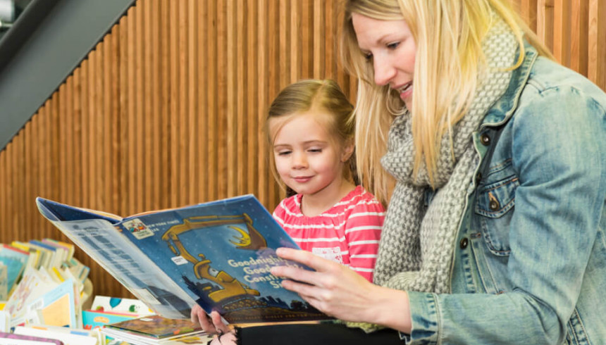 Photograph of a woman and a child reading together. 
