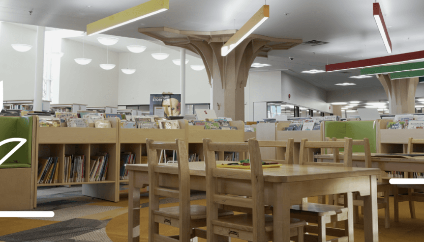 Photograph of the interior of a Calgary Public Library location. On the photo are also illustrations of red flowers. 
