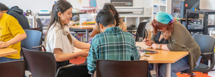 Teens sitting at a table studying.