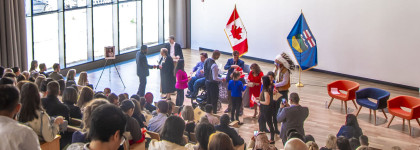An audience watches a small group of people taking part in a citizenship ceremony