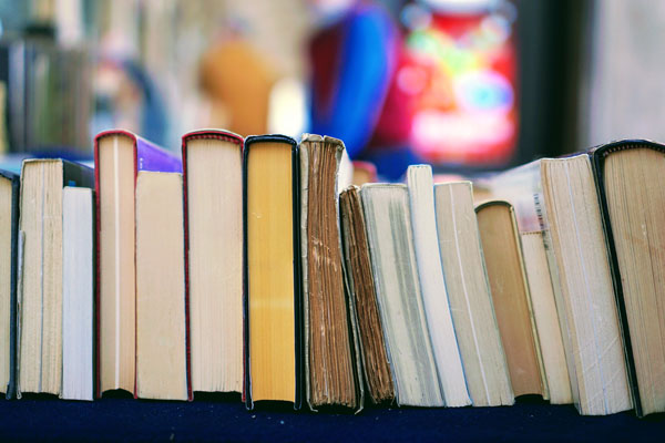 An image of books lined up on a cart. 
