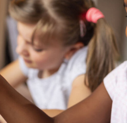 Two children engaged in math related activities. One child is using an abacus. 