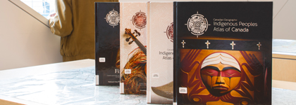 Four books that have the title Indigenous Peoples Atlas of Canada on them. 
