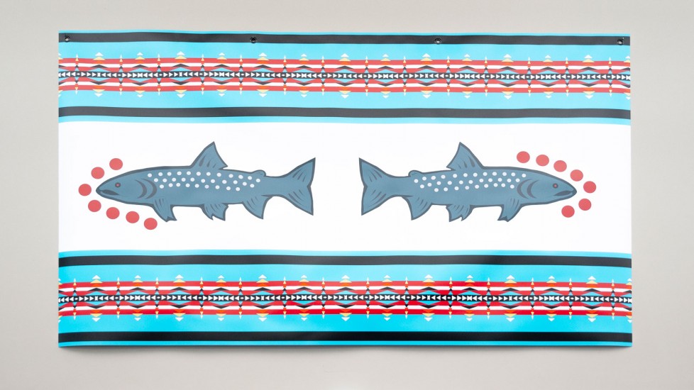 A blue banner with colourful stripes, reminiscent of Indigenous beadwork. Two stylized fish, possibly salmon, are depicted in the center, facing opposite directions. 