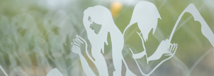 Etched on a glass panel, a man and woman face each other with mountains in the background. The artistic rendering has a soft, dreamlike quality.