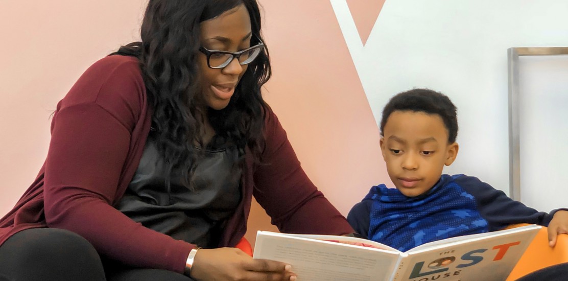 a woman and a boy reading a children's storybook together.