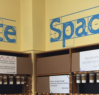Bookshelves in a corner with the words Create Space on the walls above.