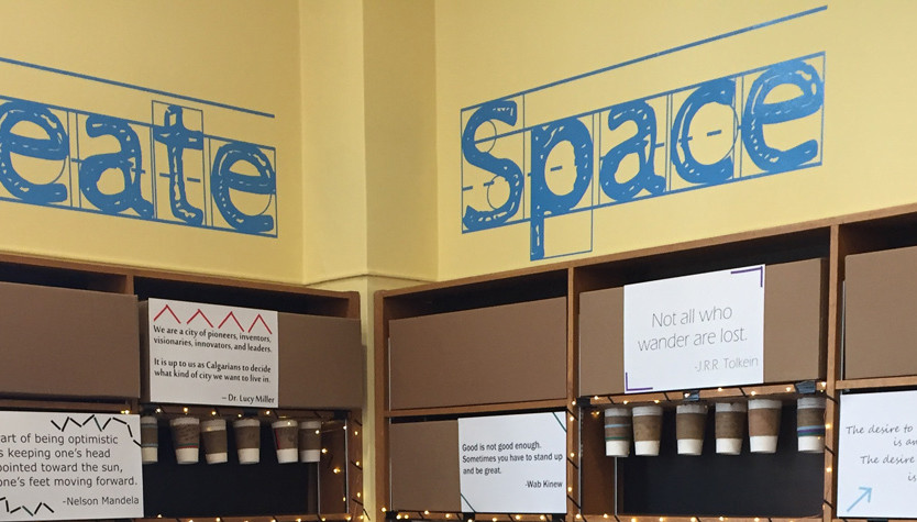 Bookshelves in a corner with the words Create Space on the walls above.