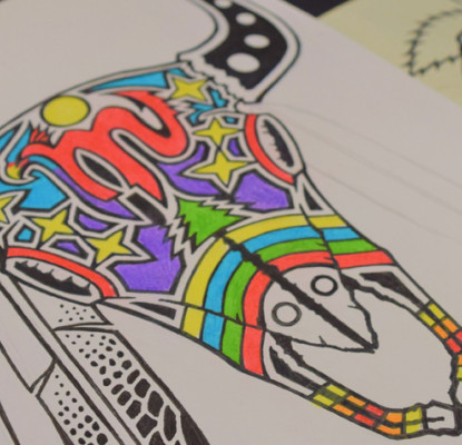 A colourful artistic drawing of a bison skull in a book on a table.