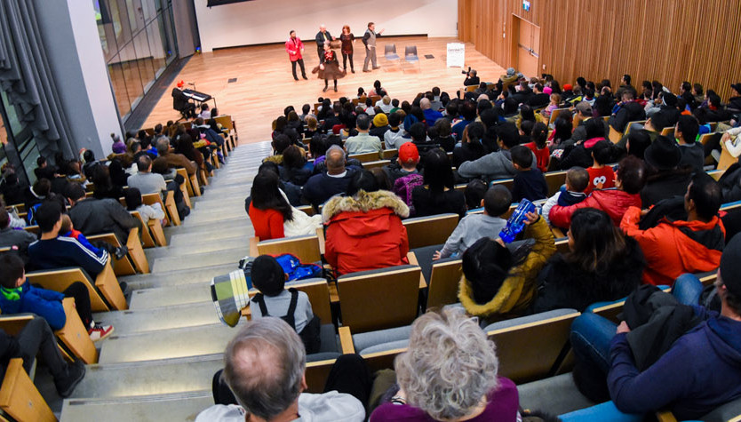 Photograph of a group of people in a performance hall. 