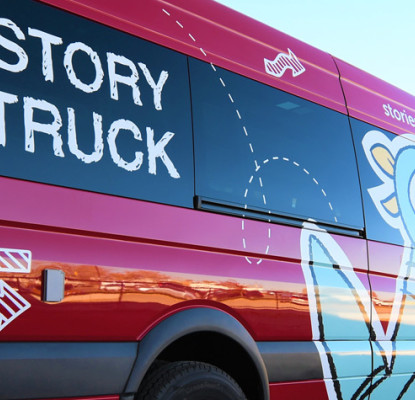 A red van with the text Story Truck on the windows and a large cartoon vinyl pigeon on the doors.