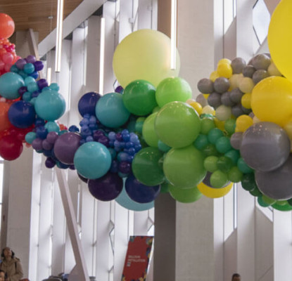 Photograph of the interior of Central Library. There is a large balloon installation suspended to the ceiling. 