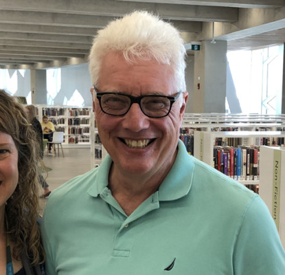 David Greer in the Calgary Public Library with a Library staff member