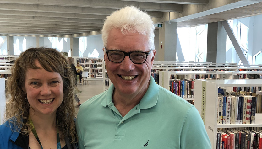 David Greer in the Calgary Public Library with a Library staff member