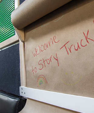 Craft paper with the words Welcome to Story Truck written in red crayon.