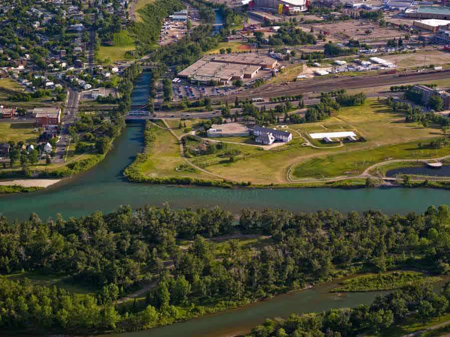background image: Aerial view of a river flowing through Calgary, Alberta. 