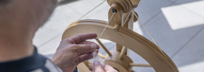 Man spinning yarn on a spinning wheel.