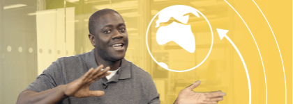 A picture of a male staff member, smiling at the camera and waving his arms. He is on a yellow background and beside him is an illustration of a earth, an arrow pointing to the early and curved lines on the right hand side.