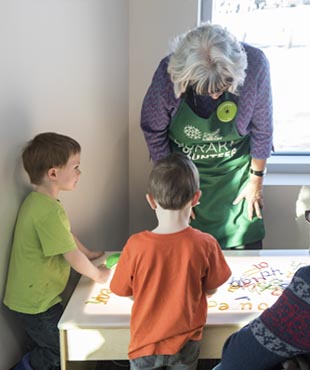 Children participating in an activity with an adult volunteer. 