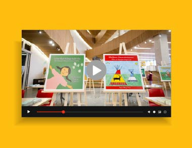 Video thumbnail showing a library space with picture book displays and a play button overlay.