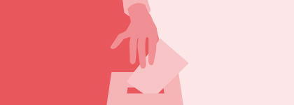 A hand is putting a vote into a box.