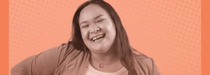 A woman smiling with an orange dotted background.