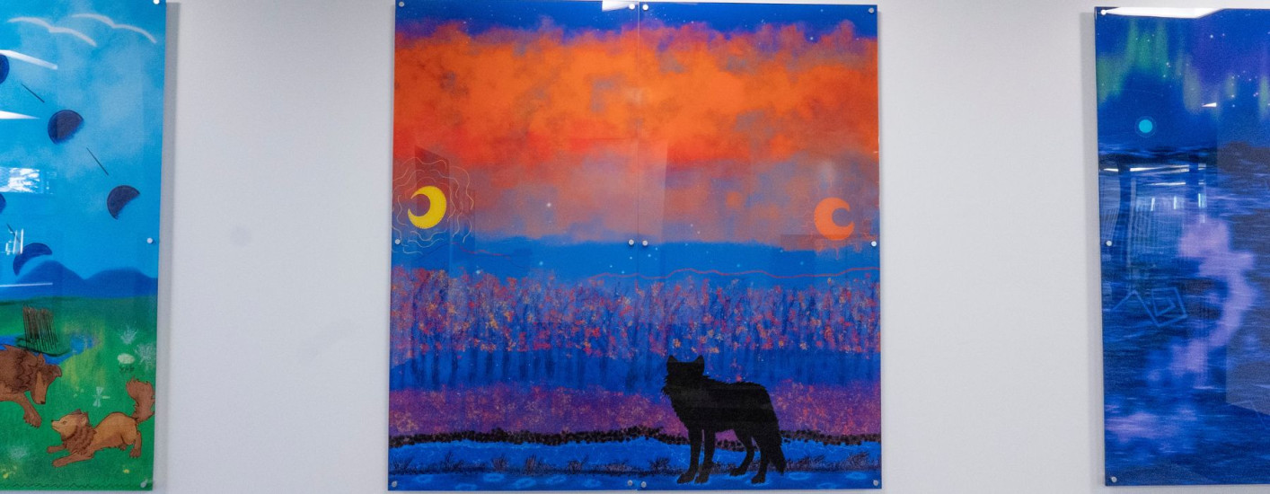 A painting of a wolf silhouette in the grass with an orange sky.