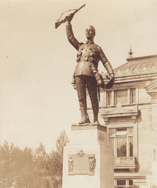 Statue of a soldier holding up a rifle in front of Memorial Park Library.