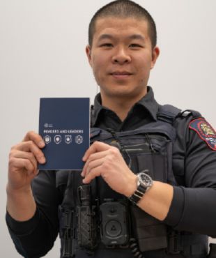 Person in uniform holding a Leaders and Readers booklet.