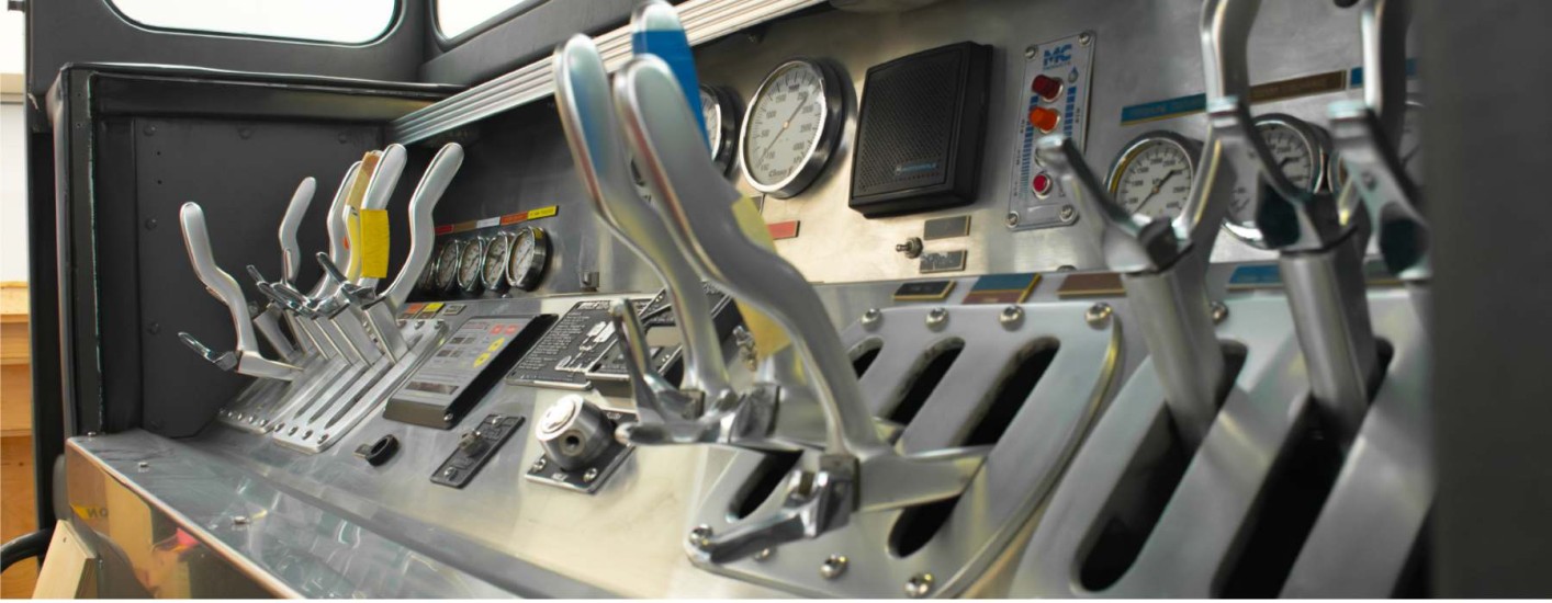 The inside of a firetruck. Levers are evident in the photo, as well as other buttons that people can play with. 
