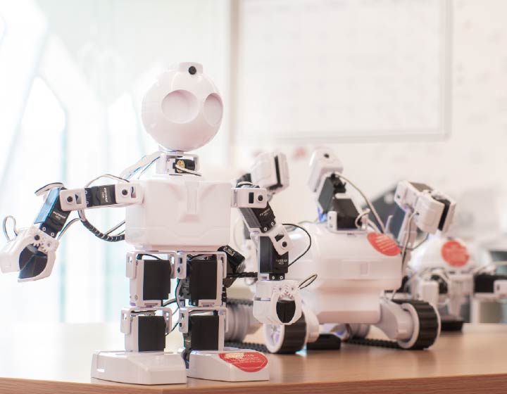 background image: Programmable robots displayed in a library learning space.