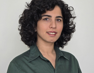 Rozsa Arts Musician Astare poses for a headshot against a plain light background.