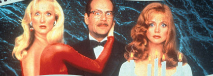 Three people in formal clothing pose together against a dark blue background, with candles in the foreground and a filmstrip-style border framing the image.