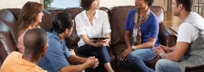 A group of adults sitting together in conversation.
