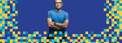 Tim Canfield standing with arms crossed in a blue shirt on a blue background with yellow, teal, and blue pixel-style blocks around the edges to promote event The Misinformation Crisis and the AI Challenge