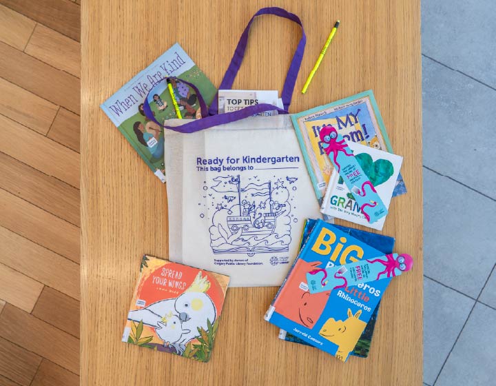 Ready for Kindergarten tote bag surrounded by children's books and learning materials.
