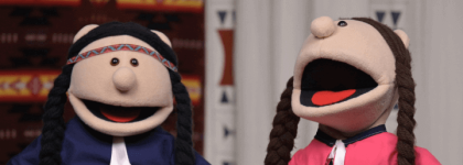 A picture of two puppets dressed in Indigenous Regalia. 