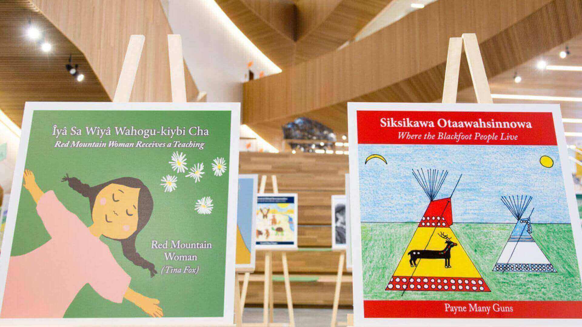 Display of Indigenous children's books on easels inside a library.