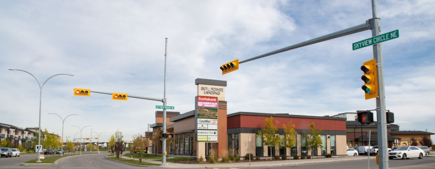 A photography of a intersection with a larger shopping centre across from it.