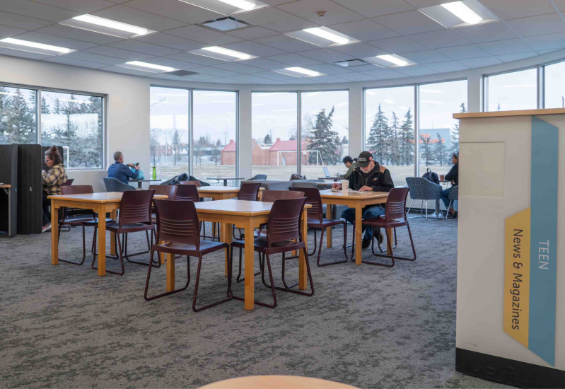 Louise Riley Library tables and chairs with large, bright windows