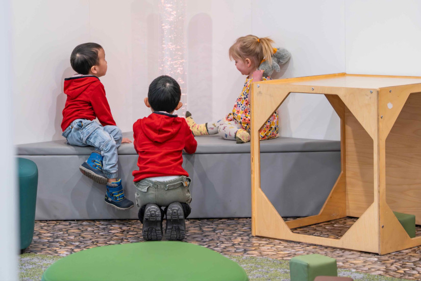 Three children looking at a bubble tube in Louise Riley Early Learning Centre